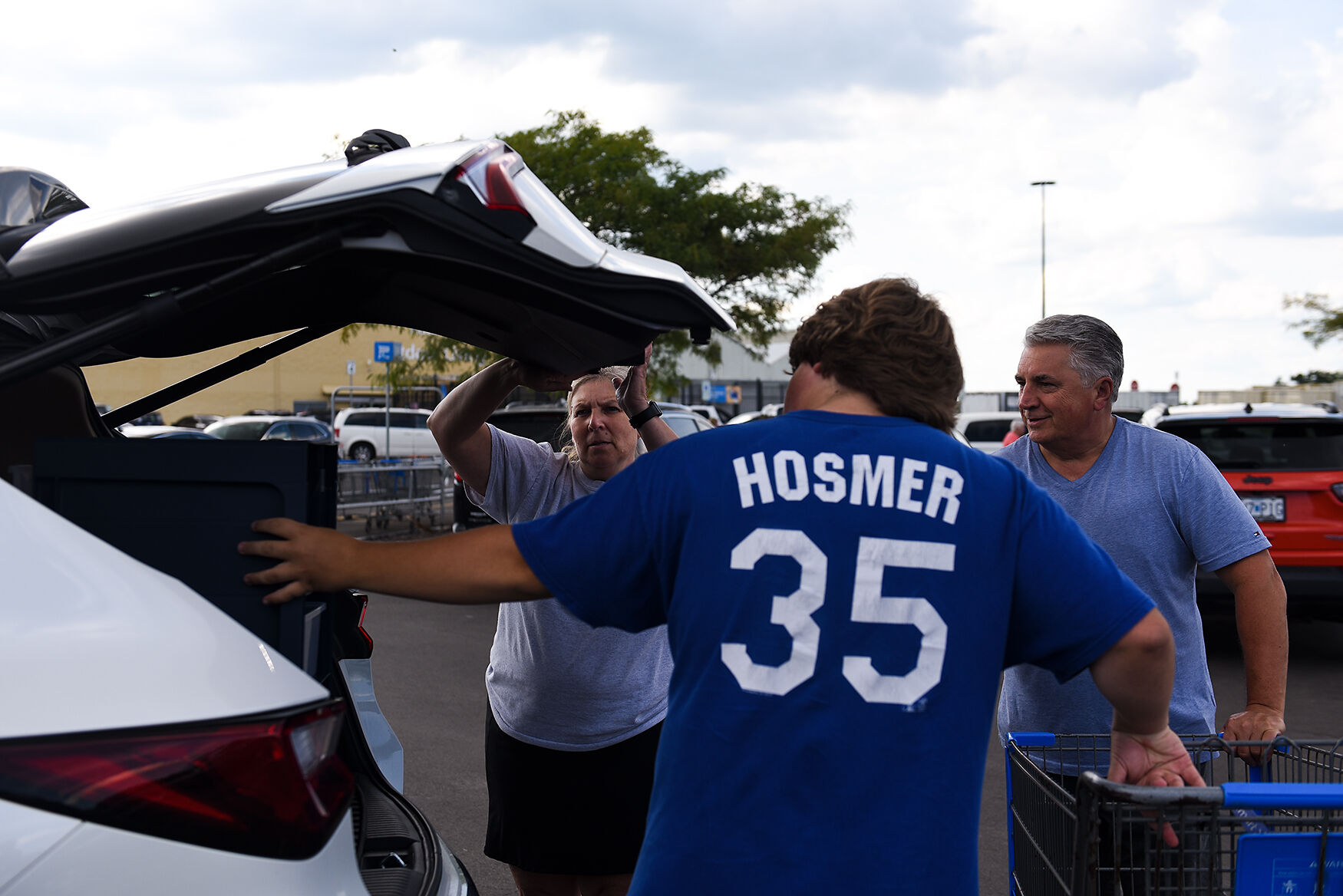 From left, Leslie Scalzo, Dominic Scalzo and Pete Scalzo load dorm supplies into their car